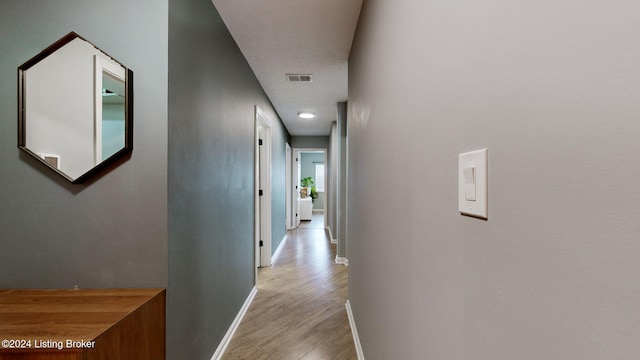 corridor with light hardwood / wood-style floors