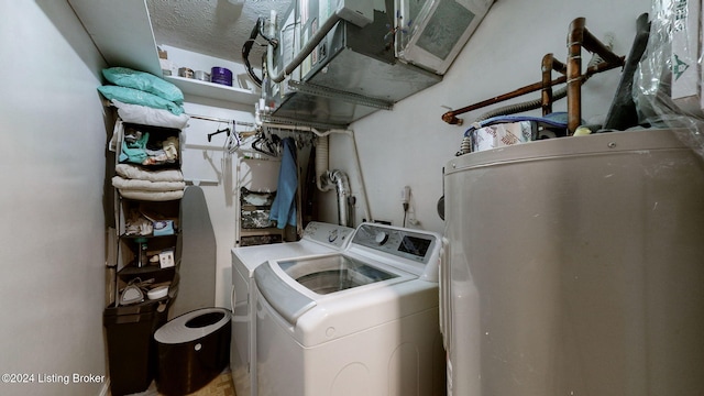 clothes washing area featuring washer and dryer and a textured ceiling