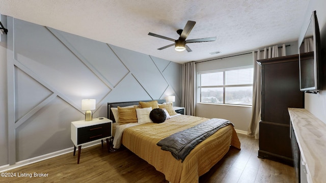 bedroom featuring a textured ceiling, dark hardwood / wood-style floors, and ceiling fan