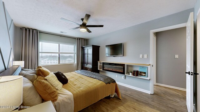 bedroom featuring wood-type flooring, a textured ceiling, and ceiling fan