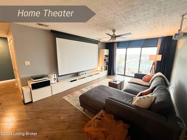 home theater with ceiling fan, wood-type flooring, and a textured ceiling