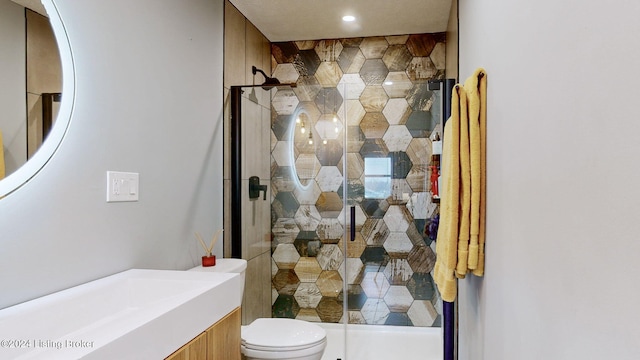 bathroom with vanity, toilet, and tiled shower