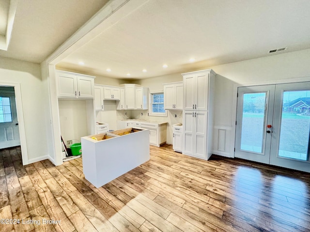 kitchen with a center island, french doors, white cabinets, and light wood-type flooring