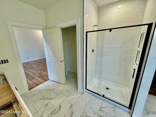 bathroom with hardwood / wood-style flooring and an enclosed shower