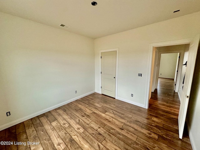 unfurnished room with hardwood / wood-style flooring