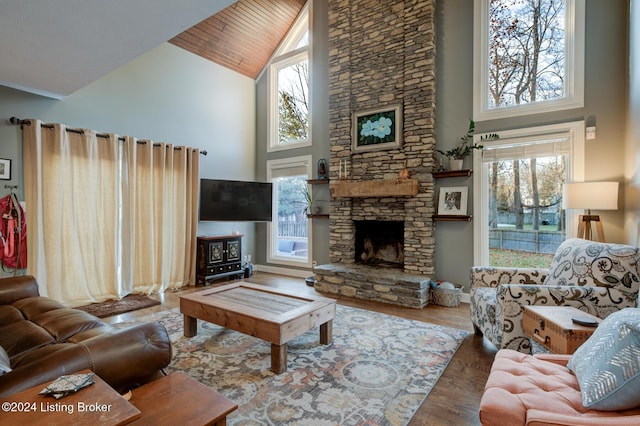 living room with a healthy amount of sunlight, wood-type flooring, and high vaulted ceiling