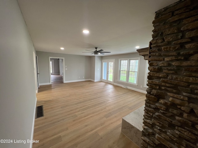 unfurnished living room with ceiling fan and light hardwood / wood-style floors