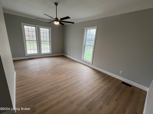 spare room with crown molding, light hardwood / wood-style flooring, and a healthy amount of sunlight