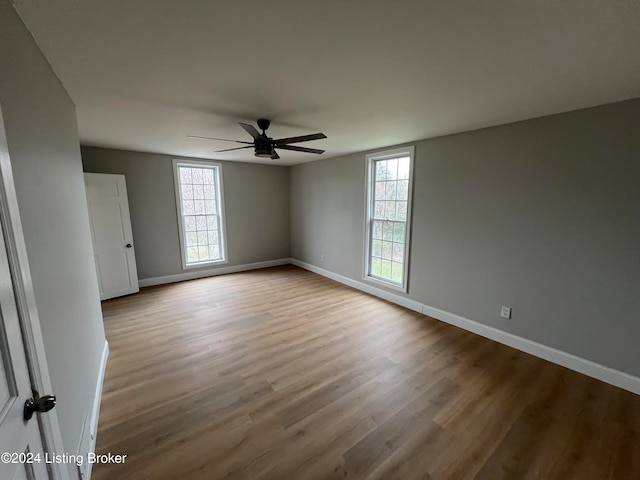 spare room featuring ceiling fan, a healthy amount of sunlight, and light wood-type flooring