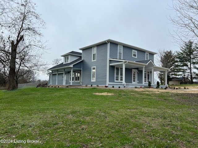 rear view of house featuring a lawn and a porch