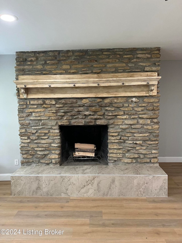 room details featuring hardwood / wood-style flooring and a stone fireplace