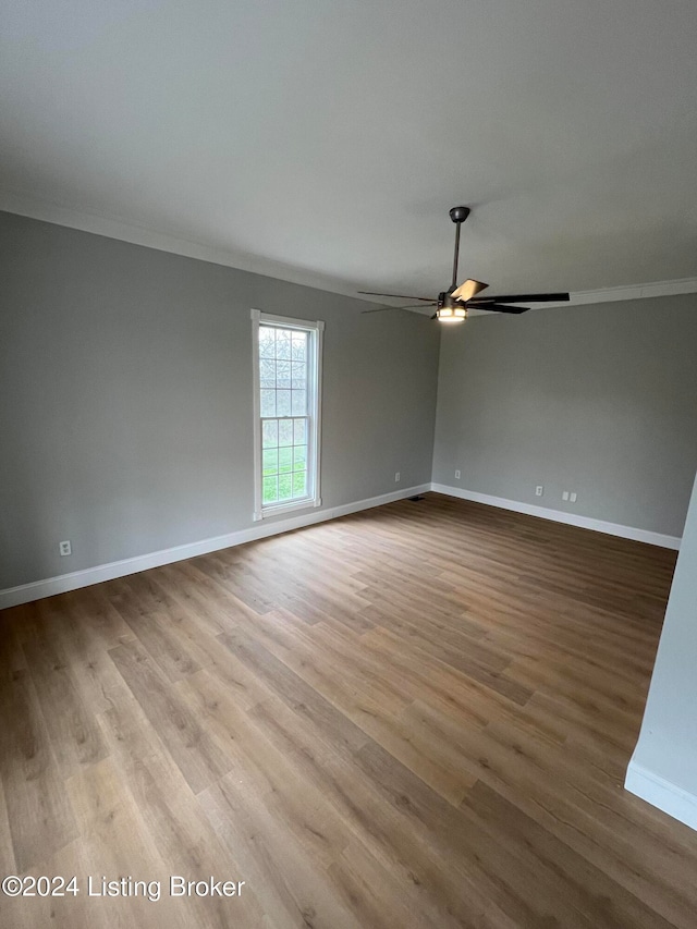 spare room featuring light hardwood / wood-style flooring, ceiling fan, and ornamental molding