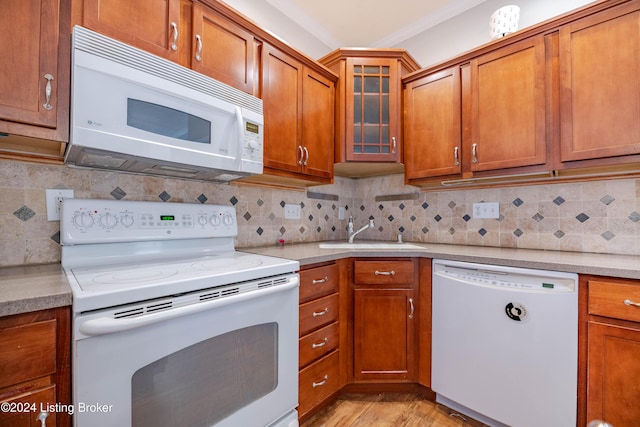 kitchen featuring tasteful backsplash, light hardwood / wood-style floors, and white appliances