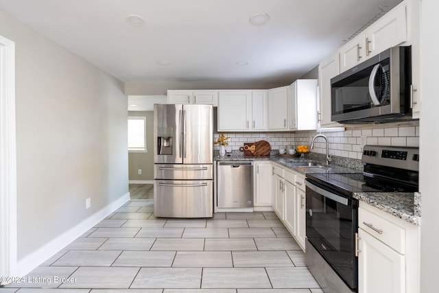 kitchen with sink, decorative backsplash, stone countertops, white cabinetry, and stainless steel appliances