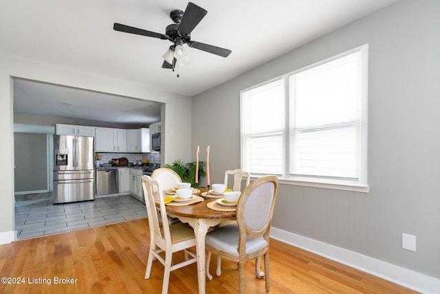 dining space with ceiling fan and light hardwood / wood-style flooring