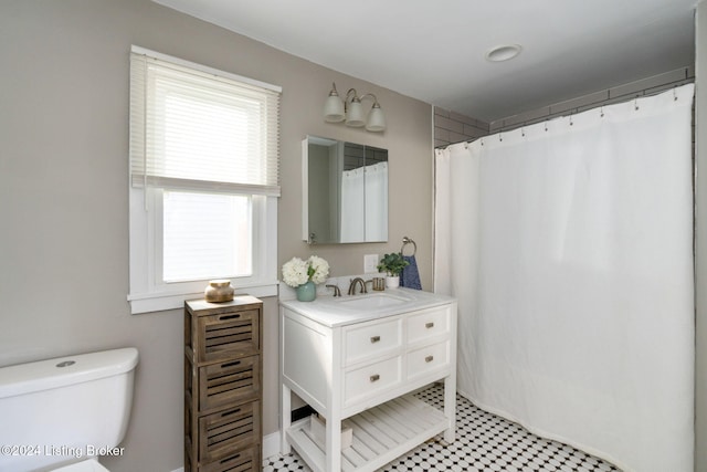 bathroom featuring curtained shower, tile patterned flooring, vanity, and toilet