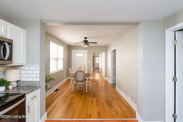 dining space with ceiling fan and light hardwood / wood-style flooring