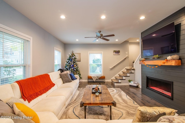 living room featuring a fireplace, dark hardwood / wood-style flooring, and ceiling fan