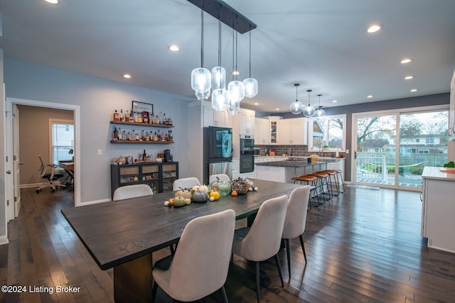 dining space with dark wood-type flooring and a notable chandelier