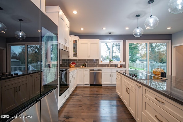 kitchen featuring black appliances, tasteful backsplash, white cabinets, and hanging light fixtures