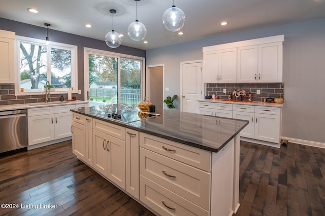 kitchen featuring dark hardwood / wood-style flooring, stainless steel dishwasher, sink, a kitchen island, and hanging light fixtures