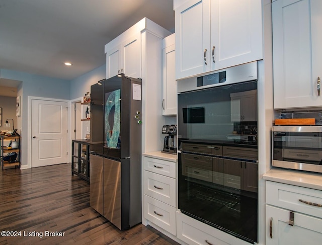 kitchen featuring white cabinets, dark hardwood / wood-style floors, appliances with stainless steel finishes, and tasteful backsplash