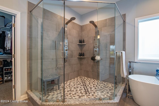 bathroom with plenty of natural light and separate shower and tub