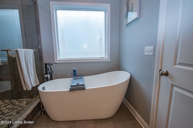 bathroom with a wealth of natural light and shower with separate bathtub