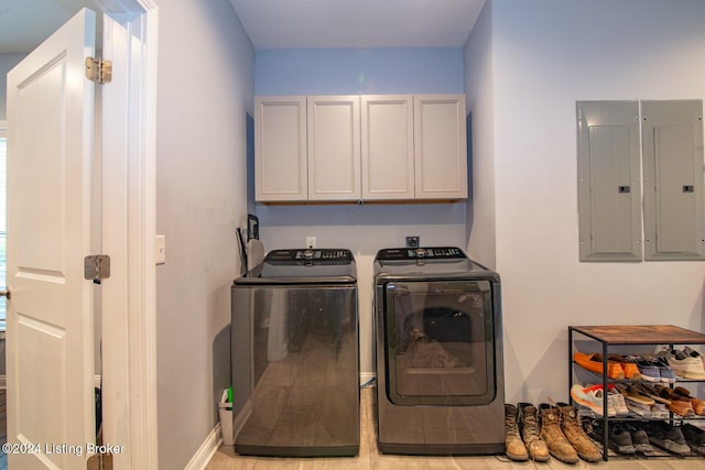 laundry area featuring washer and clothes dryer, cabinets, light tile patterned floors, and electric panel