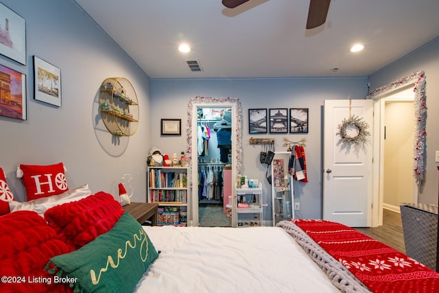 bedroom with a walk in closet, ceiling fan, a closet, and hardwood / wood-style flooring