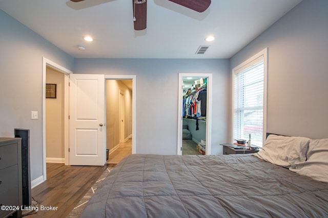 bedroom featuring wood-type flooring, a walk in closet, a closet, and ceiling fan