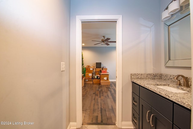 bathroom with wood-type flooring, vanity, and ceiling fan