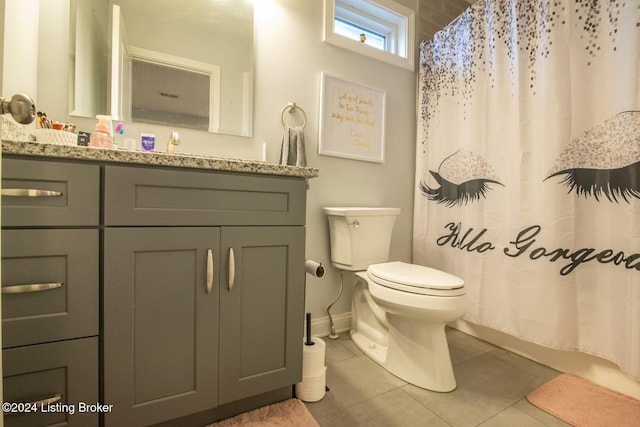 bathroom featuring tile patterned flooring, vanity, toilet, and walk in shower