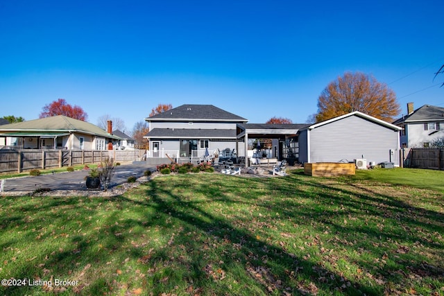 rear view of property featuring a patio and a lawn