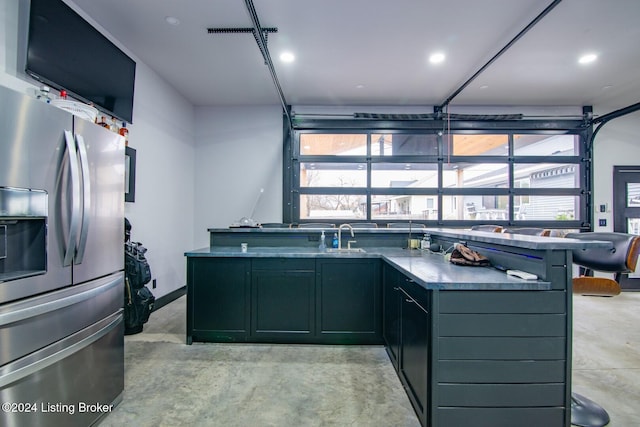 kitchen with a kitchen breakfast bar, stainless steel fridge, and sink