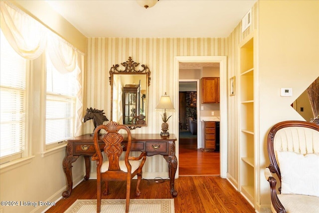 living area featuring built in shelves and dark wood-type flooring