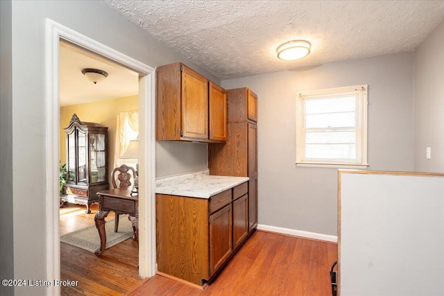 kitchen with hardwood / wood-style floors and a textured ceiling