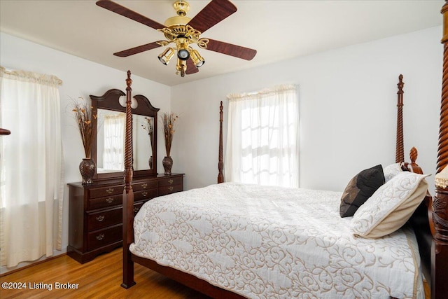 bedroom featuring multiple windows, ceiling fan, and light wood-type flooring