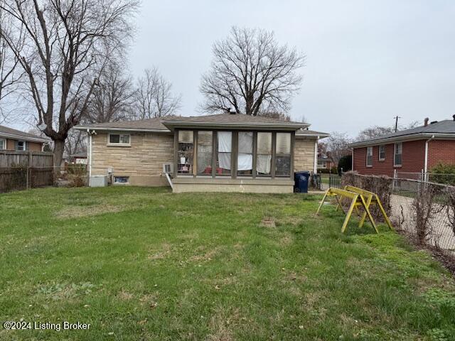 back of house with a sunroom and a yard