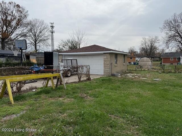 view of yard featuring a garage and an outbuilding