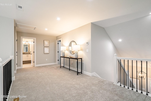 hall with lofted ceiling and light carpet