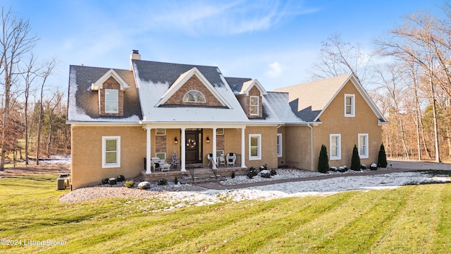 cape cod home featuring a porch and a front lawn