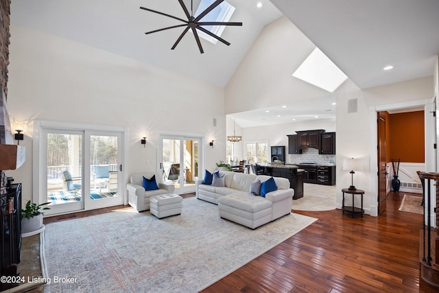 living room with a notable chandelier, dark hardwood / wood-style flooring, and high vaulted ceiling