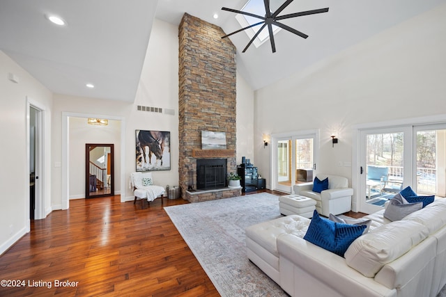 living room featuring ceiling fan, a fireplace, high vaulted ceiling, and dark wood-type flooring