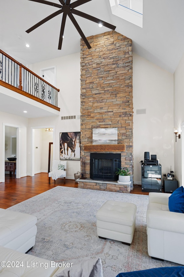 unfurnished living room featuring a stone fireplace, ceiling fan, high vaulted ceiling, and wood-type flooring