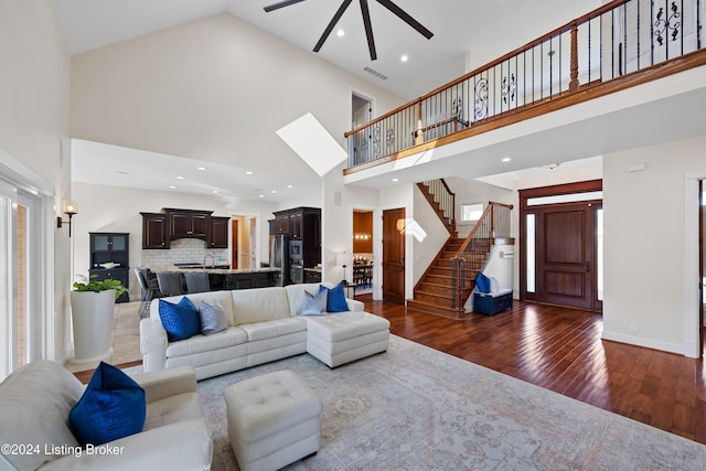 living room featuring a wealth of natural light, high vaulted ceiling, wood-type flooring, and ceiling fan