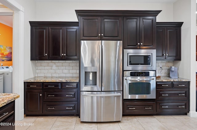 kitchen featuring tasteful backsplash, dark brown cabinets, washer and dryer, and appliances with stainless steel finishes