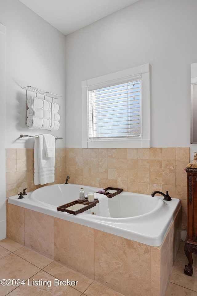 bathroom with tile patterned flooring and tiled bath