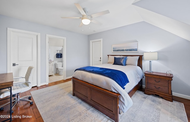 bedroom with ceiling fan, light hardwood / wood-style floors, lofted ceiling, and connected bathroom