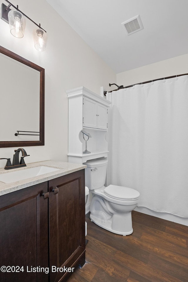 bathroom with hardwood / wood-style floors, vanity, and toilet